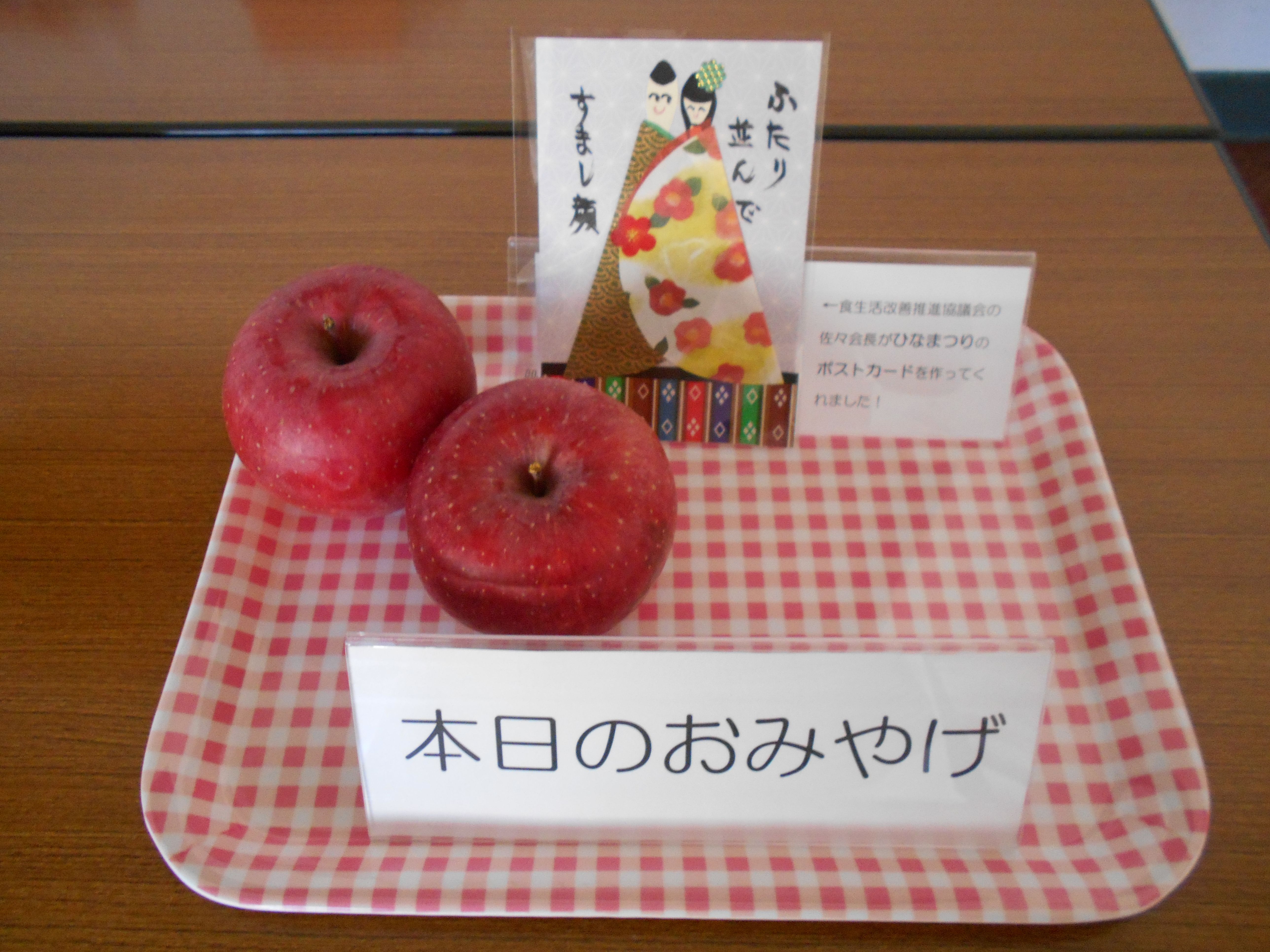 参加者のために用意したおみやげのりんごとひな祭りのポストカード